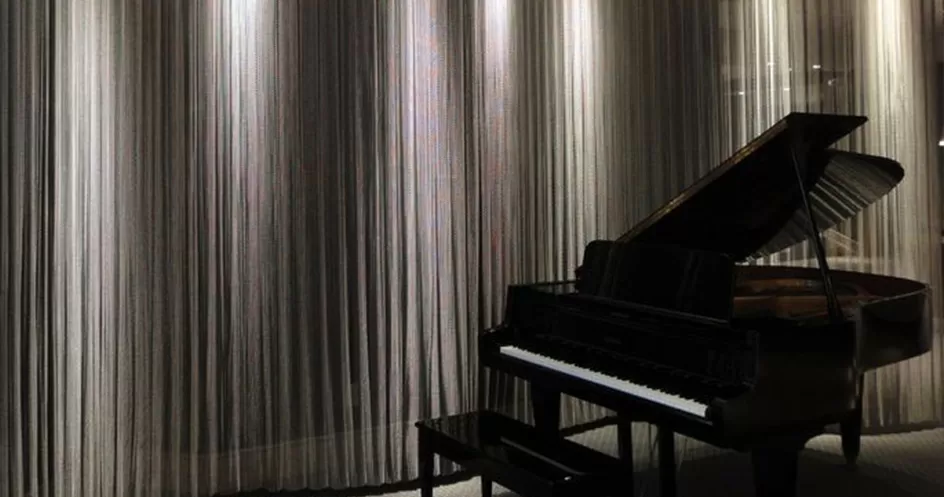 Malha metálica Dropiron ao lado de piano preto