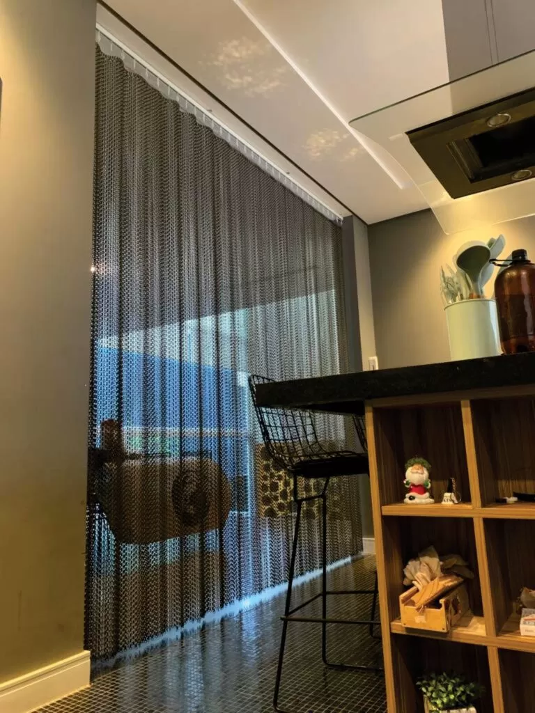 Apartamento com divisória de correntes da Dropiron entre varanda e cozinha